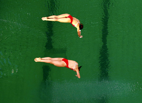 10일 리우올림픽 수영 다이빙 싱크로나이즈드 10m 플랫폼 결선에 나선 중국 선수들이 물에 뛰어들고 있다.물빛이 보통 눈에 익은 푸른색이 아니라 녹색이다. 리우데자네이루 AP 연합뉴스