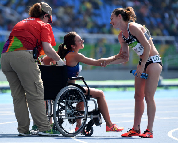 16일(현지시간) 올림픽 스타디움에서 열린 육상 여자 5000m 예선에서 뒤엉켜 넘어진 니키 햄블린(오른쪽·뉴질랜드)과 애비 다고스티노(미국)가 레이를 완주한 뒤 활짝 웃는 얼굴로 악수하고 있다. 리우데자네이루 연합뉴스 UPI