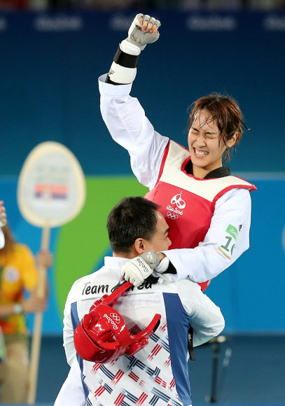 리우데자네이루올림픽 태권도 여자 49㎏급에 출전한 김소희(오른쪽)가 18일(한국시간) 열린 결승전에서 티야나 보그다노비치(세르비아)를 7-6으로 꺾고 금메달을 차지한 뒤 정광채(왼쪽) 코치와 얼싸안고 기뻐하고 있다. 리우데자네이루 올림픽사진공동취재단