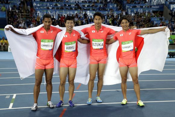 일본 남자 400m 계주 대표팀의 자메이카 혼혈 아스카 케임브리지(왼쪽부터), 기류 요시히데, 이즈카 쇼타, 야마가타 료타가 지난 20일 리우올림픽 결선에서 아시아기록을 고쳐 쓰며 은메달을 확정한 뒤 일장기를 어깨에 두른 채 포즈를 취하고 있다. 　리우데자네이루 AP 연합뉴스