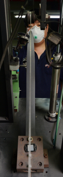 경기 안성 본사 공장에서 한 직원이 자체 개발한 장비로 선수용 활에 쓰이는 카본 날개의 중심축을 잡고 있다.