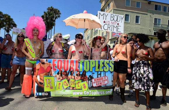 28일(현지시간) 미국 캘리포니아 주 베니스에서 시민들이 상의를 벗고 ‘고 토플리스 데이(GoTopless Day)’ 행사에 참여해 양성 평등을 주장하는 피켓을 들고 행진하고 있다. AFP 연합뉴스
