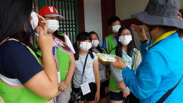 지난 6월 인천 남구의 인천향교를 찾은 아이들이 정화 활동에 앞서 문화재 전문가에게서 고택 청소 방법 등에 대해 설명을 듣고 있다.