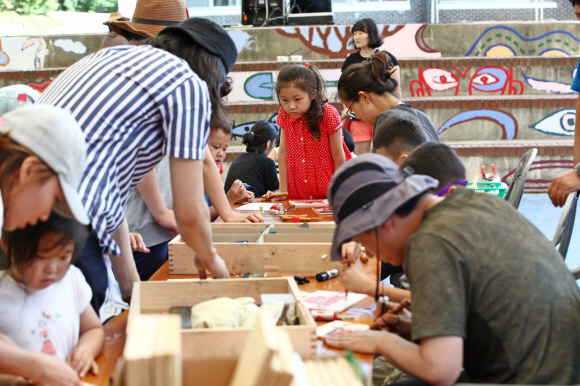 신나는 예술여행 ‘예술농장 함께’ 프로그램에 참여한 주민과 아이들이 목공예 체험을 하고 있다.