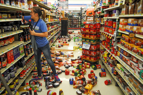 3일(현지시간) 미국 중남부 오클라호마 주 포니 시 일원에서 규모 5.6의 지진이 발생했다. 사진은 이날 오클라호마주 포니시의 한 식료품점에서 점원이 지진으로 진열대에서 쓰러진 식료품들을 정리하는 모습.  AP 연합뉴스