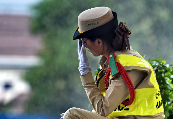 7일(현지시간) 아세안 정상회의가 열리는 라오스 비엔티안 국립컨벤션센터(NCC)에서 여성 교통경찰이 잠시 숨을 돌리고 있다.  AFP 연합뉴스