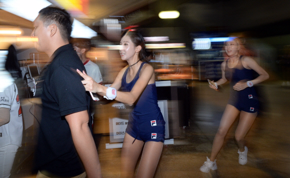 치어리더들이 5회 운동장 정비시간을 이용해 새 응원복으로 갈아입기 위해 급히 대기실로 달려가고 있다.