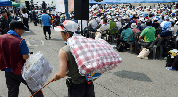 추석을 사흘 앞둔 12일 오전 서울역 광장에서 노숙인을 위한 한가위 큰잔치에 참가한 노숙인들이 이불 등 선물을 받고 있다.  도준석 기자 pado@seoul.co.kr