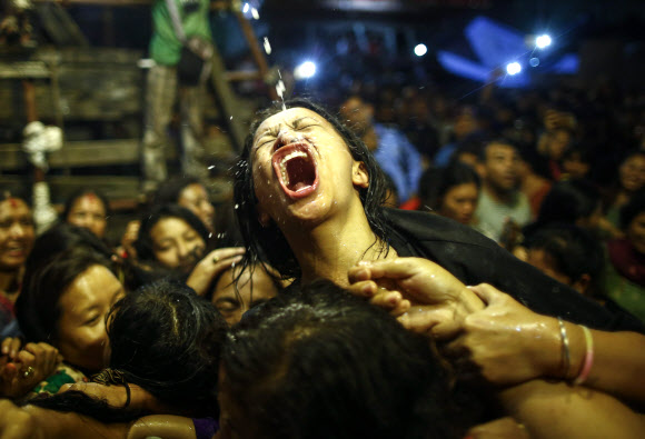 네팔의 여성과 어린 소녀들이 17일(현지시간) 네팔 카트만두 인드라 자트라 축제(Indra jatra festival)에서 파이프관을 통해 쏟아지는 술을 받아 마시기 위해 몸싸움을 하고 있다. EPA 연합뉴스