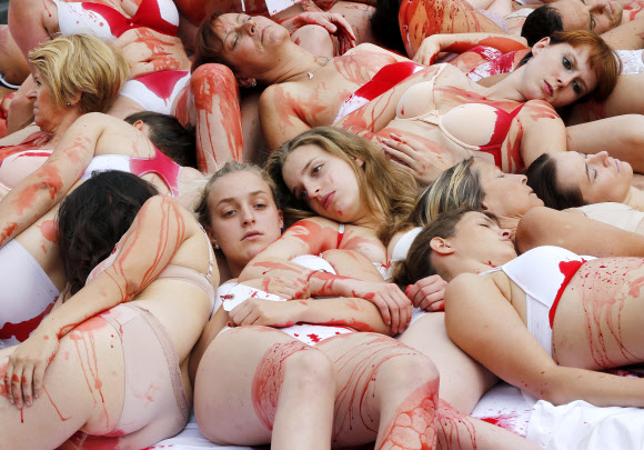 PETA(동물을 인도적으로 사랑하는 사람들) 지지자들이 16일(현지시간) 독일 프랑크푸르트 시청 앞에서 붉은 액체를 바르고 육류 사용에 시위하고 있다. AP 연합뉴스