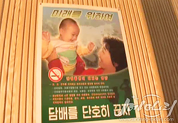 북한 인터넷 선전 매체 ’메아리’에 공개된 북한의 금연 광고. 아기를 안은 여성의 모습을 배경으로 ’담배를 단호히 끊자’라는 문구가 쓰여 있다. 연합뉴스