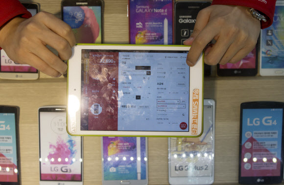서울의 한 휴대전화 매장 저가폰 코너에서 직원이 스마트폰 개통금액을 보여주고 있다. 연합뉴스