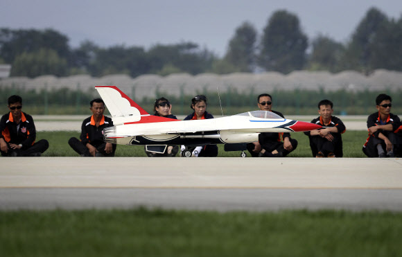 북한 관람객들이 갈마비행장 활주로에서 한국과 미국 공군의 F16 전투기를 본뜬 무선 조종 비행기의 이착륙 모습을 지켜보고 있다.  원산 AP 연합뉴스