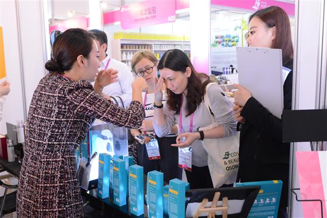 지난해 열린 오송화장품·뷰티산업엑스포에서 한 관람객이 화장품 등 미용제품을 체험해 보고 있다.<br>충북도 제공
