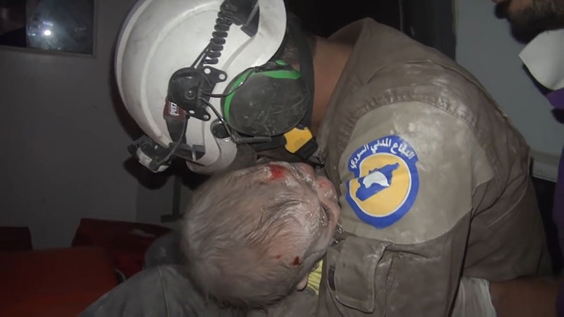 시리아 민간인 구조대원 아부키파가 아기를 꼭 끌어안고 있다. [사진=시리아 민간인 구조대]
