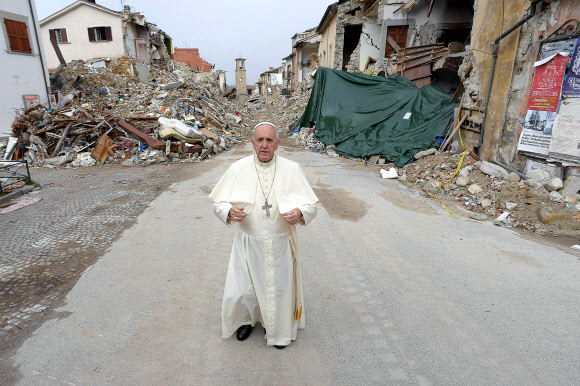 4일(현지시간) 프란체스코 교황이 지난 8월 24일 일어난 지진으로 폐허가 된 이탈리아 아마트리체를 방문해 부서진 건물의 잔해 더미 앞에 서있다. AP 연합뉴스