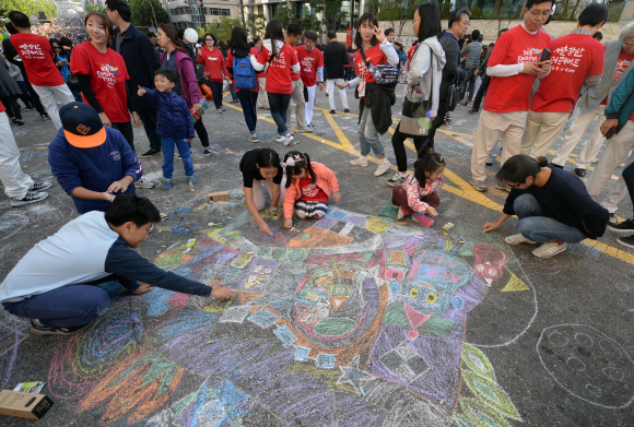 9일 서울 서초구 반포대로 서초역부터 서초3동 사거리 900m 구간에서 진행된 ‘2016 서리풀페스티벌’의 ‘지상최대 스케치북’ 행사에서 어린 아이들과 시민들이 색색의 분필들로 아스팔트에 그림을 그리고 있다.  박윤슬 기자 seul@seoul.co.kr