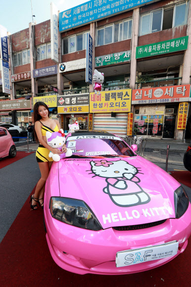 8일 서울 성동구 장안평 중고차매매시장에서 열린 ’2016 서울자동차페스티벌’에서 레이싱모델들이 드레스업카 콘테스트에 출품된 차량을 소개하고 있다. 연합뉴스