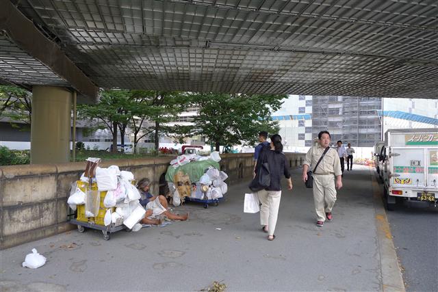 일본 경제의 상징인 일본은행 맞은편 도기와바시 다리 아래에 9일 넝마를 주워서 생계를 꾸리는 노숙자 몇몇이 가재도구들로 보이는 짐들을 옆에 놓고 쉬고 있다. 장기화된 저성장의 직격탄을 맞은 일본 중산층이 빈곤층으로 추락하는 단면을 보여 준다.
