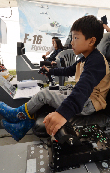 한 어린이가 F16 전투기 비행 시뮬레이터에 앉아 조종간을 직접 조작해 보고 있다. 부여 손형준 기자 boltagoo@seoul.co.kr