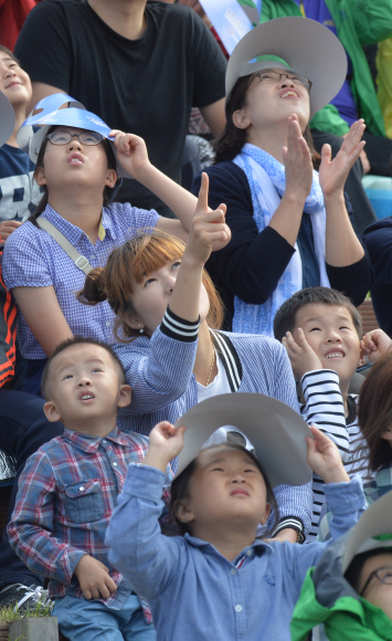 항공 레저스포츠 제전을 찾은 가족 단위 관람객들이 에어쇼를 보며 탄성을 지르고 있다. 부여 손형준 기자 boltagoo@seoul.co.kr