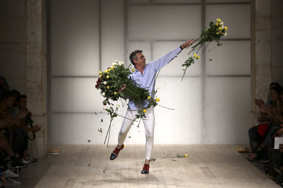 패션 디자이너 필리페 파이스카(Filipe Faisca)가 9일(현지시간) 포르투갈 리스본에서 열린 리스본 패션위크 중 자신의 패션쇼에서 쇼가 끝난 후 무대로 나와 관객들을 향해 꽃을 던지고 있다. EPA 연합뉴스