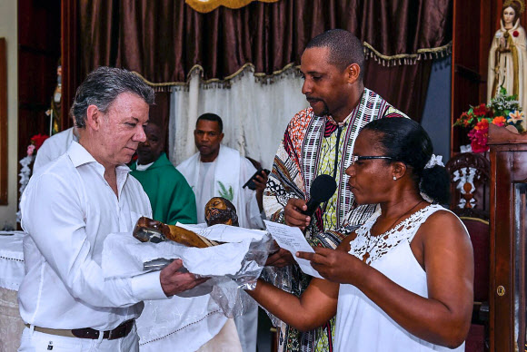 올해 노벨평화상 수상자로 선정된 후안 마누엘 산토스(왼쪽) 콜롬비아 대통령이 9일(현지시간) 북서부 초코주 보하야에서 52년간 지속된 내전의 희생자를 추모하는 종교 행사에 참석해 위로하고 있다. 보하야 AFP 연합뉴스