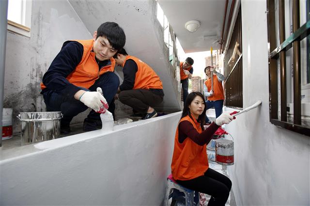 한화건설 임직원들이 지난 14일 서울 양천구 신정동의 한 취약계층 가정집 벽면에 페인트칠을 하고 있다. 한화 제공