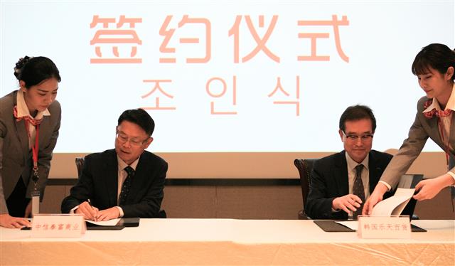 이원준(오른쪽) 롯데백화점 대표가 지난 14일 중국 상하이에서 열린 중신그룹과의 합작 소매유통회사 설립 조인식에서 서명하고 있다. 롯데백화점 제공