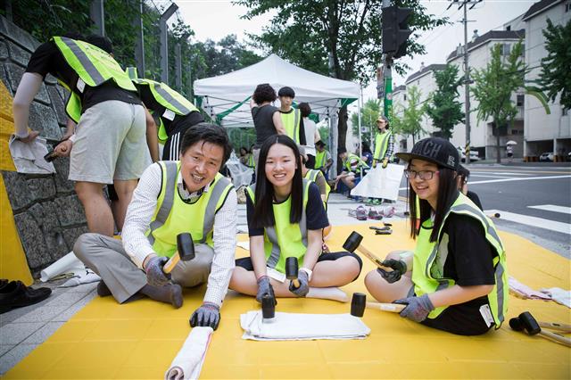 강범석 인천 서구청장이 어린이들의 안전한 통학로 조성을 위해 천마초등학교 앞 횡단보도에 학생들과 함께 옐로카펫을 설치하고 있다. 인천 서구 제공