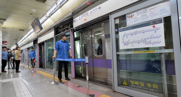 19일 오전 승강장안전문(스크린도어)에 30대 남성이 끼어 숨지는 사고가 발생한 서울 지하철 5호선 김포공항역 승강장에서 역 관계자들이 사고 후 개방해 놓은 스크린도어를 통제하고 있다. 2016. 10. 19 손형준 기자 boltagoo@seoul.co.kr