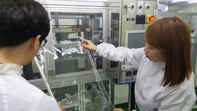 23일 코오롱인더스트리의 연구원이 새로 개발한 투명 폴리이미드의 상태를 점검하고 있다. 디스플레이 장치에 사용되는 투명 폴리이미드는 구부리거나 휘는 스마트폰 개발에 사용될 가능성이 높다.