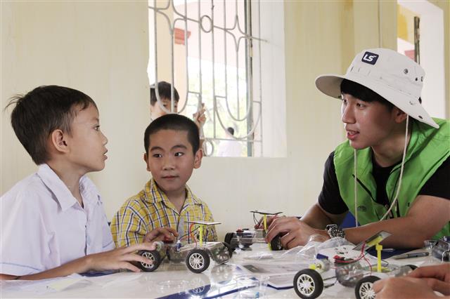 지난 8월 베트남을 찾은 LS 대학생 해외봉사단원이 현지 초등학생들과 태양광 자동차 과학키트를 만들고 있다. LS그룹 제공