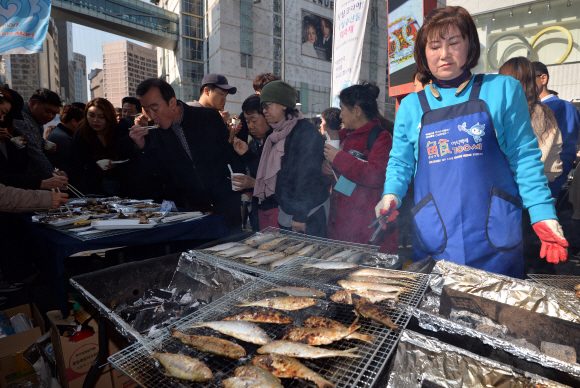 3일 서울 명동에서 ’싱싱코리아! 싱싱수산물 대축제(대한민국 바다를 세일합니다)’를 홍보하기 위해 열린 행사에 참석한 시민들이 전어와 각종회를  시식하고 있다.  박지환기자 popocar@seoul.co.kr