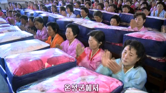 북한 함경북도 수해지역 이재민들이 김정은 노동당 위원장이 전달한 담요를 전달받는 모습. 조선중앙TV는 김정은이 주민들에게 담요를 보냈다는 소식을 3일 전하면서 주민들이 ”친 어버이의 육친적 사랑에 뜨거운 격정을 금치 못했다”고 밝혔다. 연합뉴스