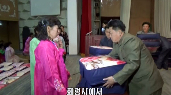 북한 함경북도 수해지역 이재민들이 김정은 노동당 위원장이 전달한 담요를 전달받는 모습. 조선중앙TV는 김정은이 주민들에게 담요를 보냈다는 소식을 3일 전하면서 주민들이 ”친 어버이의 육친적 사랑에 뜨거운 격정을 금치 못했다”고 밝혔다.  연합뉴스