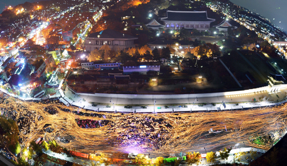 박근혜 대통령 퇴진을 촉구하는 3차 촛불집회에 참여한 100만 시민의 촛불이 서울 경복궁 앞 도로를 가득 메우고 있다. 촛불의 흐름과 청와대 전경을 다중촬영해 합성했다. 사진공동취재단