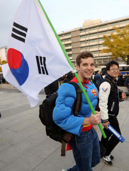 슈퍼맨으로 분장한 외국인이 태극기를 들고 집회 현장을 향해 걸어가고 있다. 연합뉴스