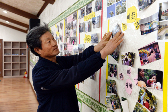 권 대표가 체험 프로그램에 참가한 가족들의 사진을 벽에 붙이고 있다.