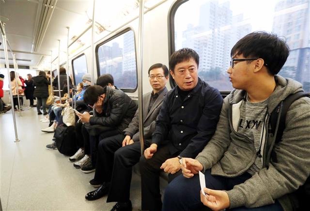 시민생활에 귀품  경전철로 출근하는 정 시장이 등교 중인 학생과 대화를 나누고 있다.<br>용인시 제공