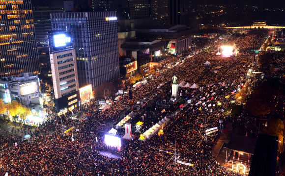 19일 오후 서울 광화문광장 일대에서 열린 ’최순실 게이트’ 진상규명과 박근혜 대통령 퇴진을 촉구하는 4차 촛불집회에 참석한 시민들이 촛불을 들고 있다.  사진공동취재단