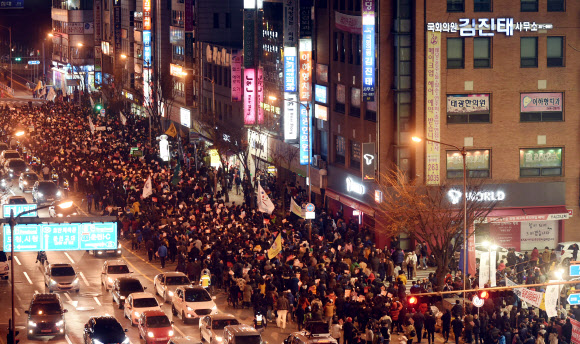19일 오후 강원 춘천시 로데오 사거리에서 시국집회가 열려 참가자들이 박근혜 대통령 하야 촉구 등을 외치며 김진태 의원 사무실까지 거리행진을 하고 있다.    연합뉴스