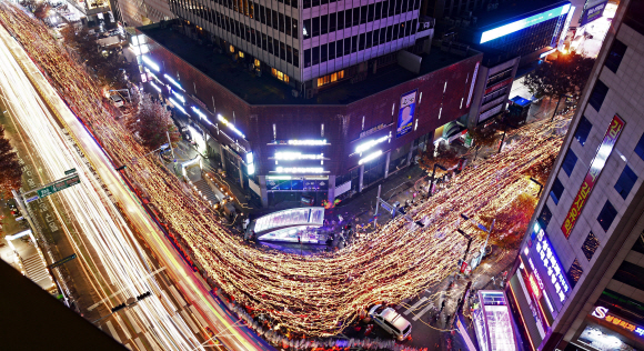 박근혜 대통령의 퇴진을 촉구하는 제3차 대구 시국 대회가 19일 저녁 대구 중구 대중교통 전용지구에서 열렸다. 1만 5천여 명(주최추산)의 집회 참가자들이 촛불을 들고 행진을 하고 있다.  사진공동취재단