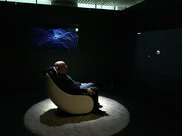 추상적으로 존재하는 감정을 출력해 보여주는 ‘브레인 팩토리‘. 작가 모리스 베나윤이 의자에 앉아 의식을 집중시키고 있다.