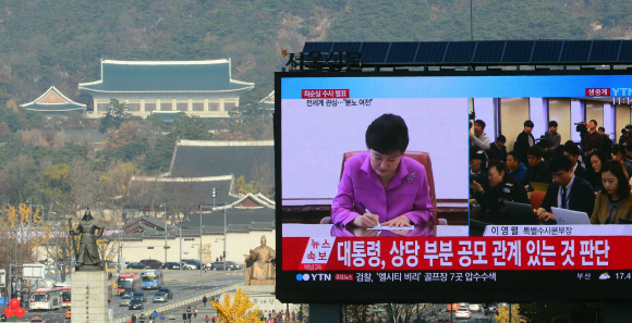 20일 서울 중구 태평로 서울신문사 전광판을 통해 ‘비선 실세’ 최순실씨의 국정 농단 사건에 대한 검찰의 중간 수사 발표가 송출되고 있다. 전광판 뒤쪽에 청와대가 보인다. 정연호 기자 tpgod@seoul.co.kr