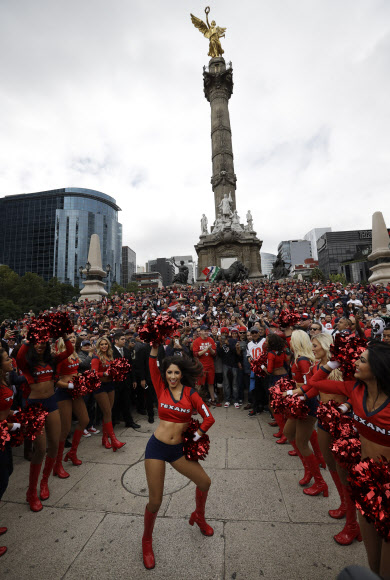 20일(현지시간) NFL 휴스턴 텍슨스의 치어리더들이 멕시코의 멕시코시티 천사의 탑 아래서 열띤 응원을 펼치고 있다. NFL은 히스패닉 팬들을 끌어들이기 위해 21일(현지시간) 휴스턴 텍슨스와 오클랜드 레이더스의 경기를 멕시코시티에서 개최하기로 했다. AP 연합뉴스