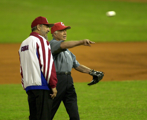 피델 카스트로(왼쪽)가 2002년 5월 14일 아바나의 에스타디오 라티노아메리카노에서 열린 올스타 경기 시구에 앞서 몸을 푸는 지미 카터 미국 대통령과 얘기를 나누고 있다.  AP 자료사진 