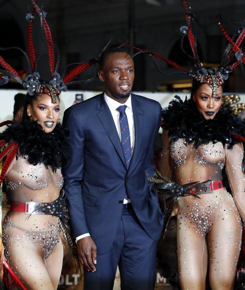 ‘세계에서 가장 빠른 사나이’ 우사인 볼트가 28일(현지시간) 영국 런던의 레스터 스퀘어에서 열린 다큐멘터리 영화 ‘아이 엠 볼트(I Am Bolt)’ 시사회에서 댄서들과 함께 포즈를 취하고 있다. AFP 연합뉴스