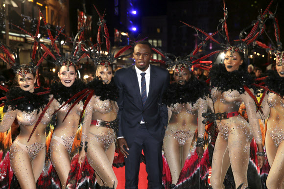 ‘세계에서 가장 빠른 사나이’ 우사인 볼트가 28일(현지시간) 영국 런던의 레스터 스퀘어에서 열린 다큐멘터리 영화 ‘아이 엠 볼트(I Am Bolt)’ 시사회에서 댄서들과 함께 포즈를 취하고 있다. AP 연합뉴스