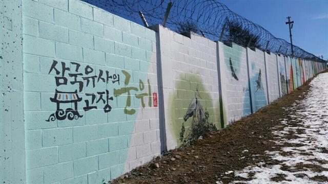 경북 군위군 부계면 동산리 팔공산 정상 비로봉 인근 군부대 담장에 군의 주요 관광지와 특산물이 벽화로 그려져 있다. 삼국유사의 고장 군위 홍보문구.